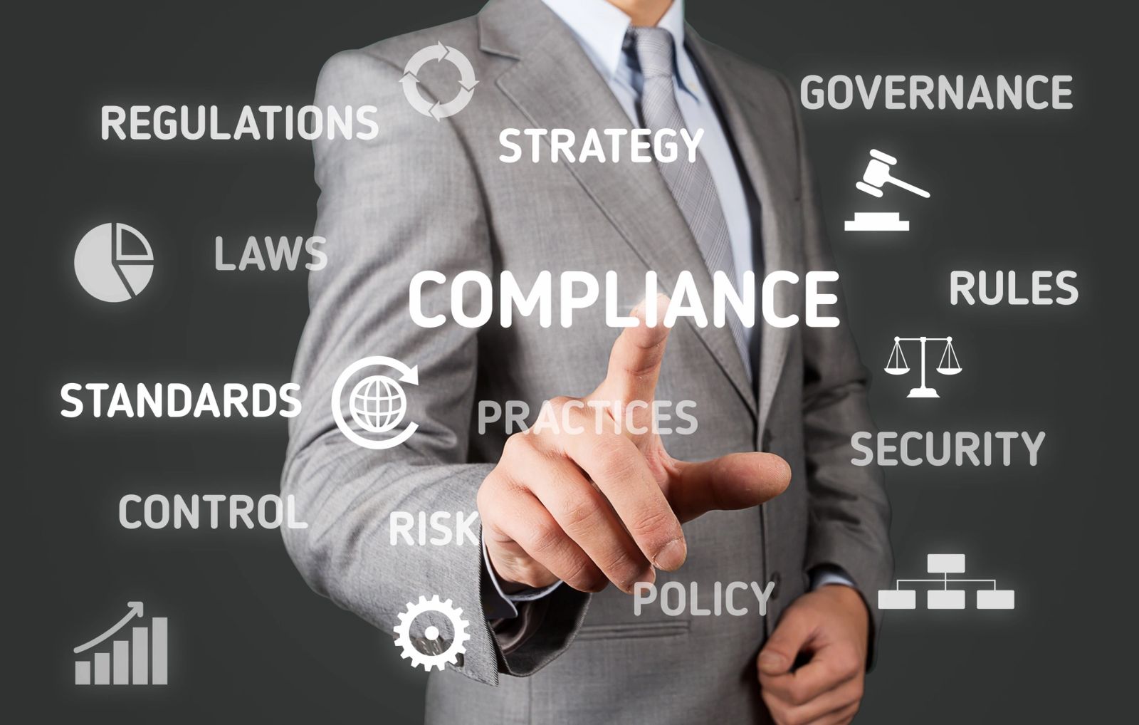 Businessman in suit pointing at the word 'COMPLIANCE' among related terms.
